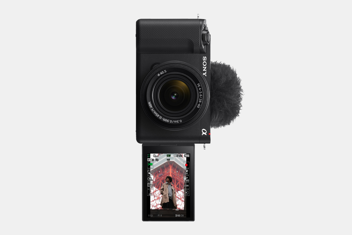 ZV-E1 相機的圖片，LCD 顯示屏翻轉至前方，垂直資訊顯示屏上顯示一名男子的影像